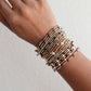 A multicolored beaded bracelet made with gemstones and metal beads, displayed on a wrist.